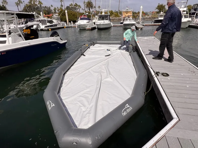 Slide: The Image of Inflatable Eco dry dock by Center Console, 2025 model, at marina with boats and dock. - 5