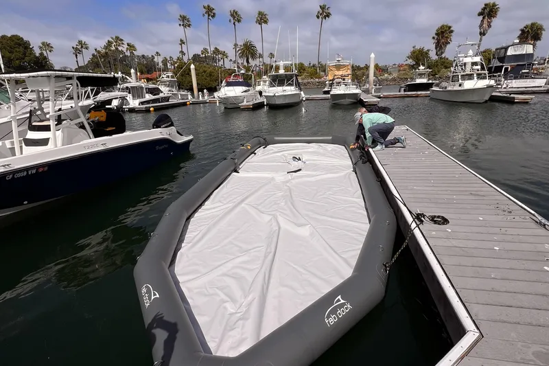 Slide: The Image of Center Console Eco Dry Dock 2025 at marina with boats and palm trees. - 6
