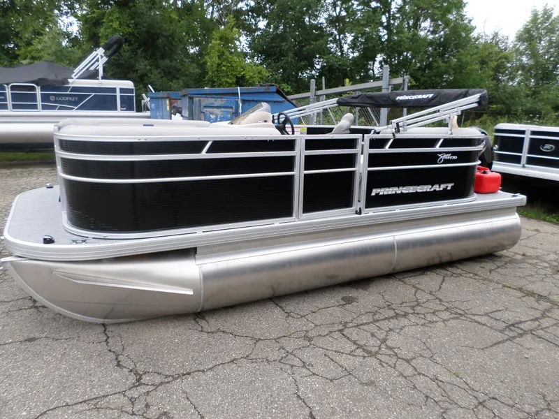 Slide: The Image of 2024 Princecraft Jazz 170 pontoon boat, black and silver, parked outdoors. - 1