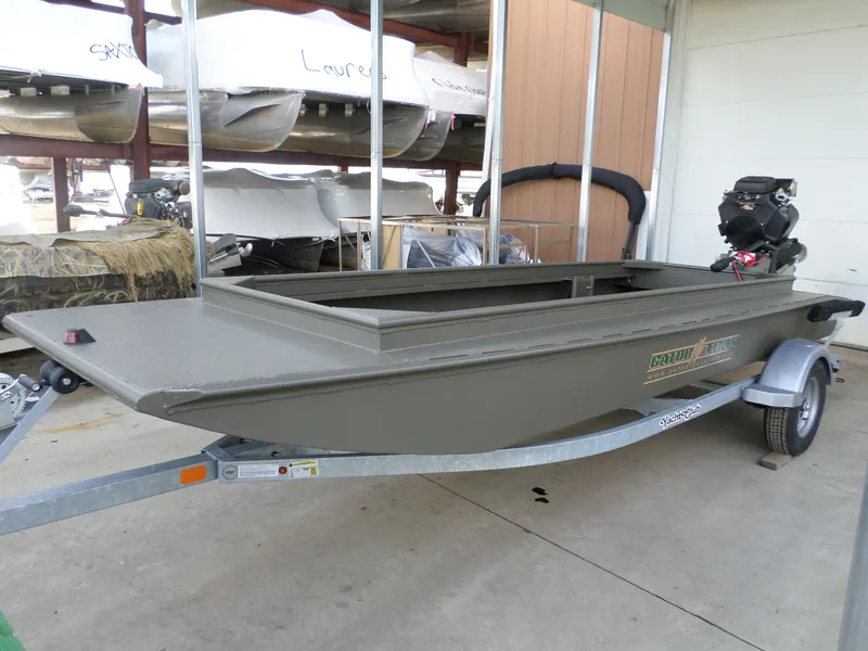 Slide: The Image of 2024 Gator Trax 16 Marsh Series boat on trailer in storage facility. - 1