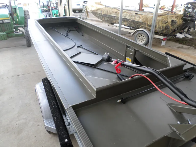 Slide: The Image of 2024 Gator Trax 16 Marsh Series boat in a garage, showcasing interior and controls. - 5