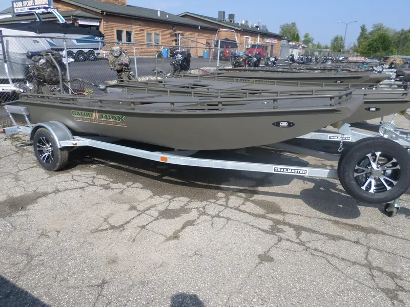 Slide: The Image of 2024 Gator Trax 1862 3 Man Hide boat on a trailer in a parking lot. - 1