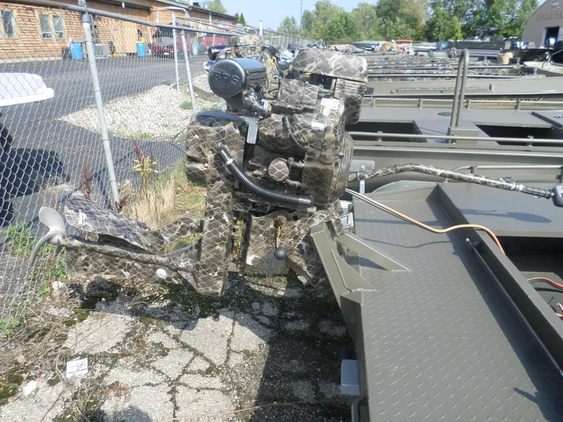 Slide: The Image of 2024 Gator Trax 1862 3 Man Hide boat with camouflaged motor in outdoor setting. - 4