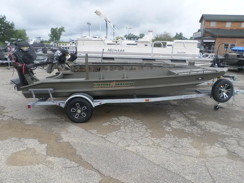 Slide: The Image of 2024 Gator Trax 1544 boat on trailer, parked outdoors, with overcast sky. - 1