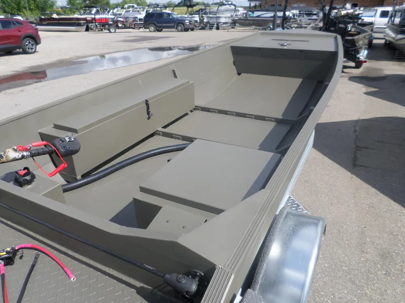 Slide: The Image of 2024 Gator Trax 1644 GE boat on trailer, open interior view, parked outdoors. - 2