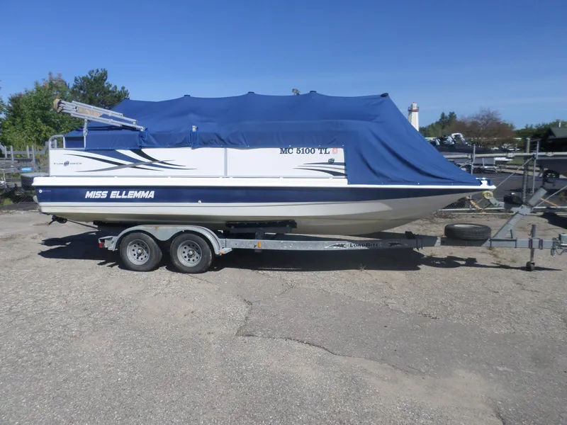 Slide: The Image of 2012 Hurricane 236 Fun Deck boat on trailer, covered with blue tarp. - 1