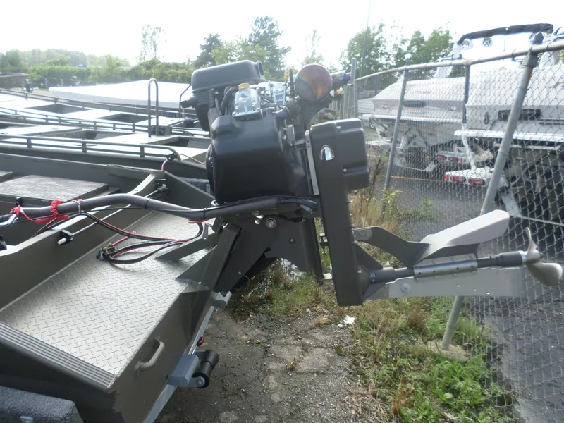 Slide: The Image of 2024 Gator Trax 1750 GE boat motor and propeller detail in a fenced storage area. - 4