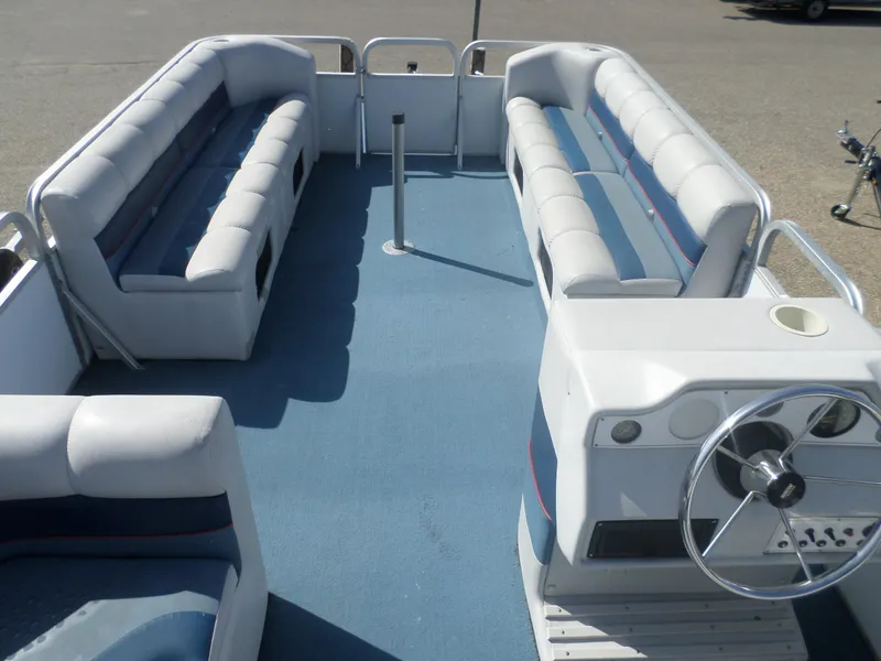 Slide: The Image of 1994 Manitou 24 pontoon boat interior with blue carpet and cushioned seating. - 3
