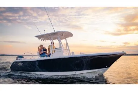 Slide: The Image of 2022 Sea Hunt Ultra 229 boat cruising at sunset on calm waters. - 14