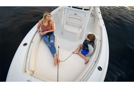 Slide: The Image of 2022 Sea Hunt Ultra 229 boat with two people relaxing on deck. - 2