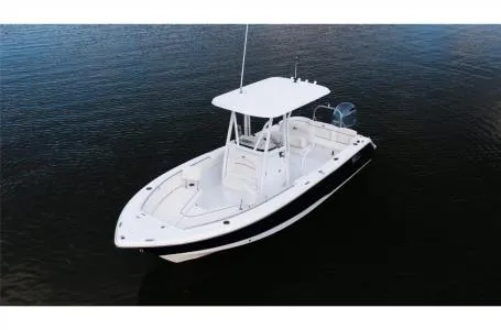 Slide: The Image of 2022 Sea Hunt Ultra 229 boat on calm water, featuring sleek design and spacious deck. - 23