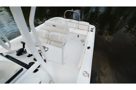 Slide: The Image of 2022 Sea Hunt Ultra 229 boat interior with seating and controls on calm water. - 7