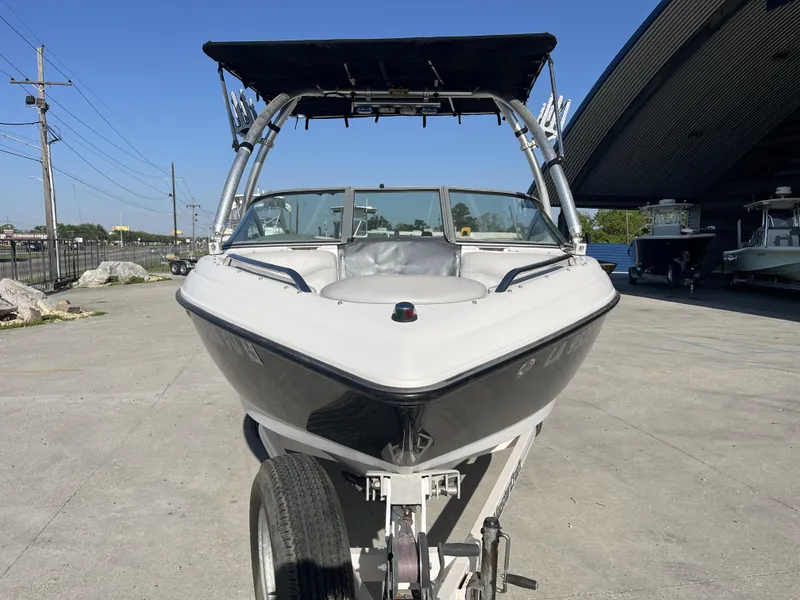 Slide: The Image of 2006 MasterCraft MariStar 210 boat on trailer, parked outdoors under clear blue sky. - 11