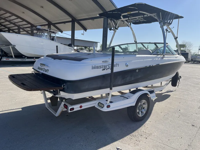 Slide: The Image of 2006 MasterCraft MariStar 210 boat on trailer under a canopy. - 3