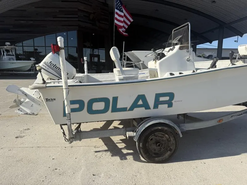 Slide: The Image of 1997 Polar 17 CC boat on trailer, with Johnson outboard motor, parked outside a building. - 6