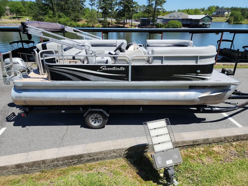 Slide: The Image of 2012 Sweetwater SW 2086 pontoon boat on trailer by a scenic lake. - 3