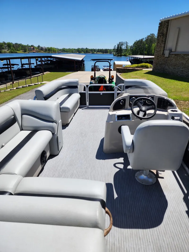 Slide: The Image of Pontoon boat interior with gray seating, steering console, and lake view; Sweetwater SW 2086, 2012 model. - 5