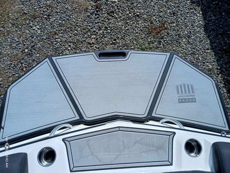 Slide: The Image of 2021 MasterCraft XT20 boat swim platform on gravel surface. - 4