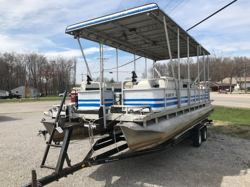 Slide: The Image of 1995 Manitou 24 Spirit pontoon boat on trailer, parked outdoors. - 0
