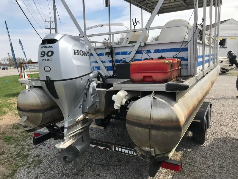 Slide: The Image of 1995 Manitou 24 Spirit pontoon boat with Honda 90 VTEC outboard motor on a trailer. - 1