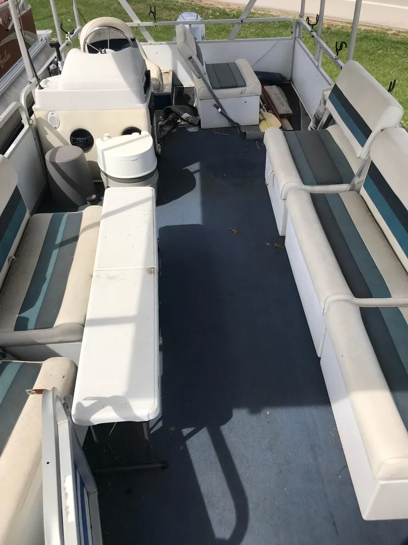 Slide: The Image of 1995 Manitou 24 Spirit pontoon boat interior with seating and steering console. - 3
