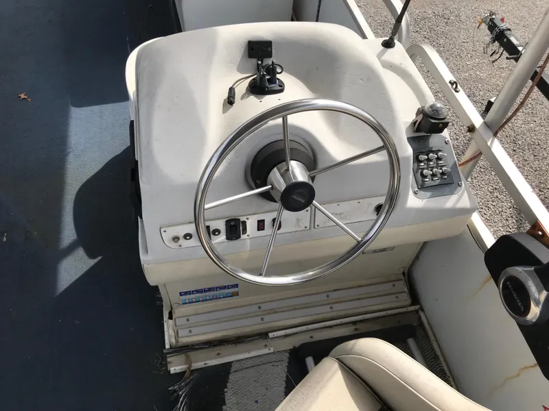 Slide: The Image of Steering console of a 1995 Manitou 24 Spirit boat with controls and a metal wheel. - 5