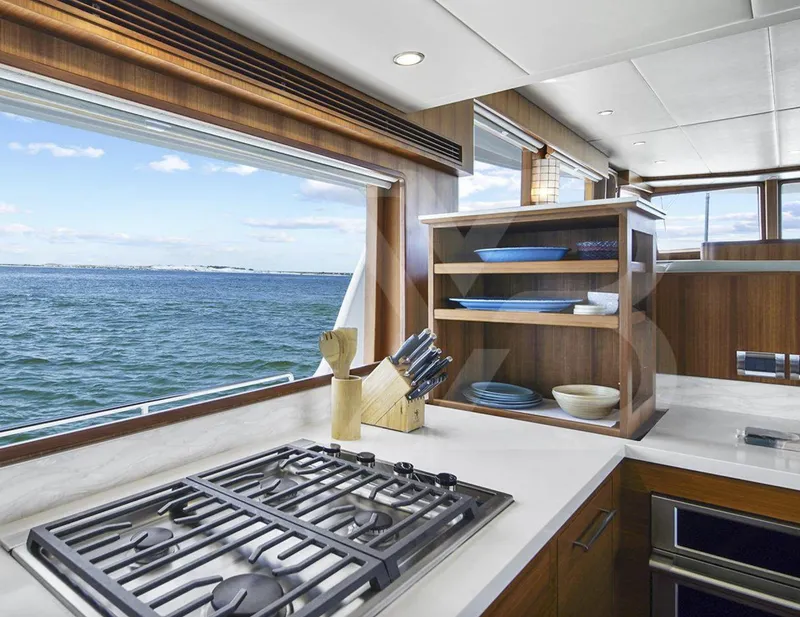 Slide: The Image of 2023 Outer Reef Yachts 720 Azure kitchen with ocean view, featuring modern appliances and wooden cabinetry. - 14