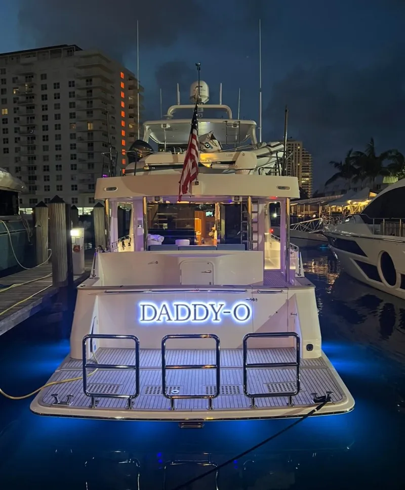 Slide: The Image of 2023 Outer Reef Yachts 720 Azure Custom Cockpit Motoryacht docked at night with illuminated name. - 5