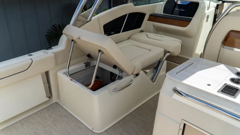 Slide: The Image of 2025 Chris-Craft Calypso 28 boat interior with open storage compartment and beige seating. - 19