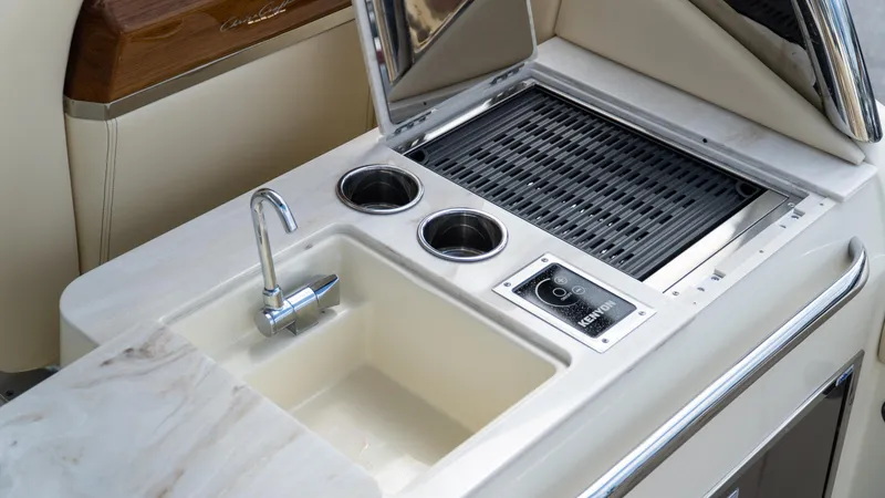 Slide: The Image of 2025 Chris-Craft Calypso 28 boat kitchen with sink, grill, and cup holders. - 24