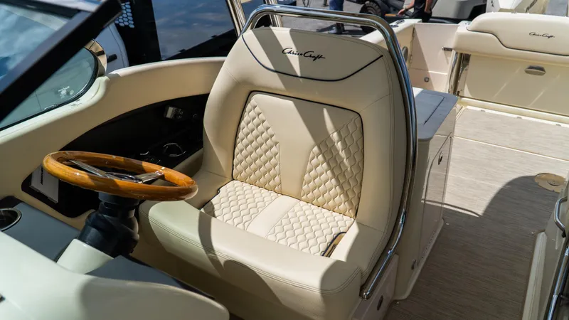 Slide: The Image of 2025 Chris-Craft Calypso 28 boat interior with luxurious seating and wooden steering wheel. - 33
