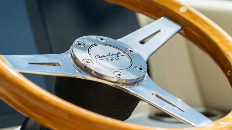 Slide: The Image of Steering wheel of 2025 Chris-Craft Calypso 28 boat, featuring wood and metal design. - 36