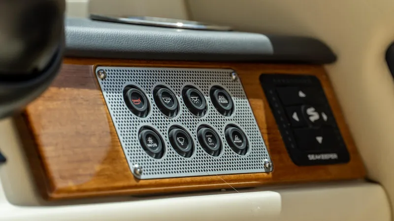 Slide: The Image of Control panel of 2025 Chris-Craft Calypso 28 boat, featuring sleek buttons and wood finish. - 39