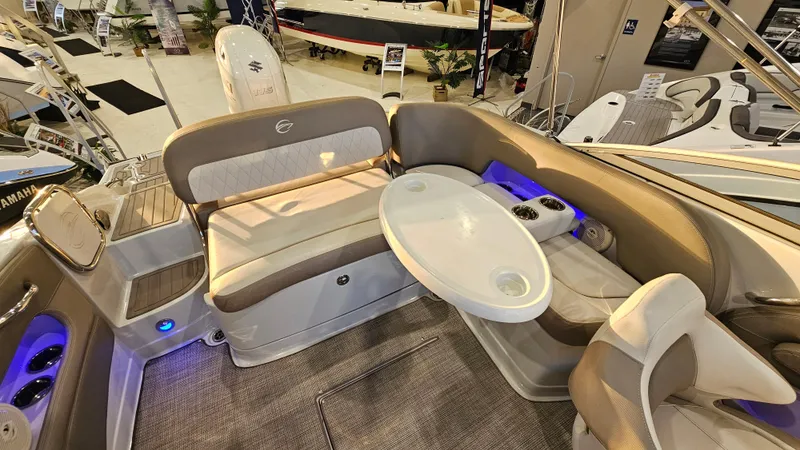 Slide: The Image of 2020 Crownline Eclipse E215 XS boat interior with seating and table, featuring modern design and lighting. - 13