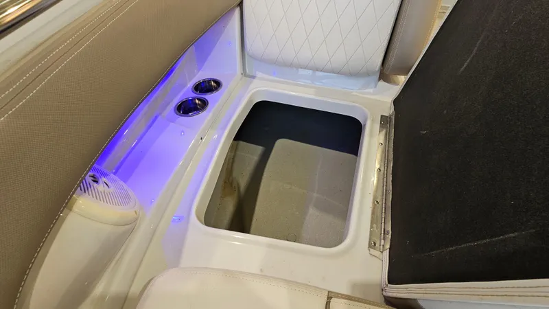 Slide: The Image of 2020 Crownline Eclipse E215 XS boat interior storage compartment with cup holders and ambient lighting. - 24