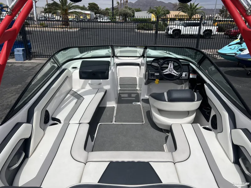 Slide: The Image of 2018 Yamaha AR195 boat interior with seating and steering wheel, parked outdoors. - 4