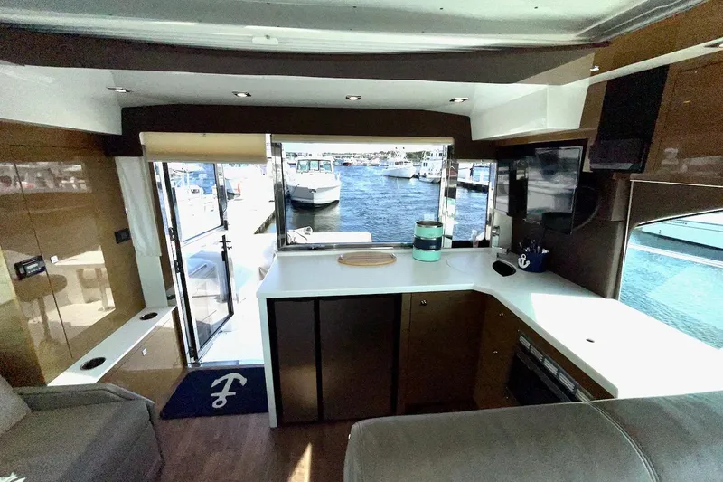 Slide: The Image of Interior of 2018 Cruisers Yachts 45 Cantius with marina view through open doors. - 15