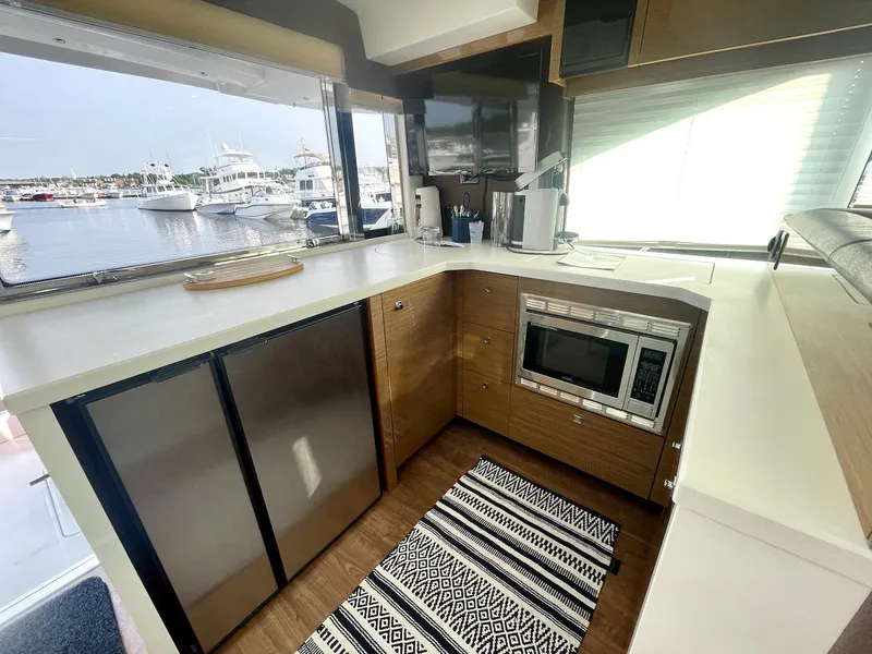 Slide: The Image of Modern kitchen interior of 2018 Cruisers 45 Cantius yacht with appliances and marina view. - 16