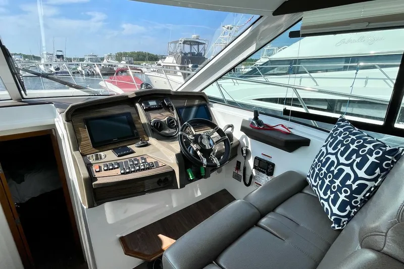 Slide: The Image of 2018 Cruisers Yachts 45 Cantius helm with modern controls and nautical-themed pillow. - 27