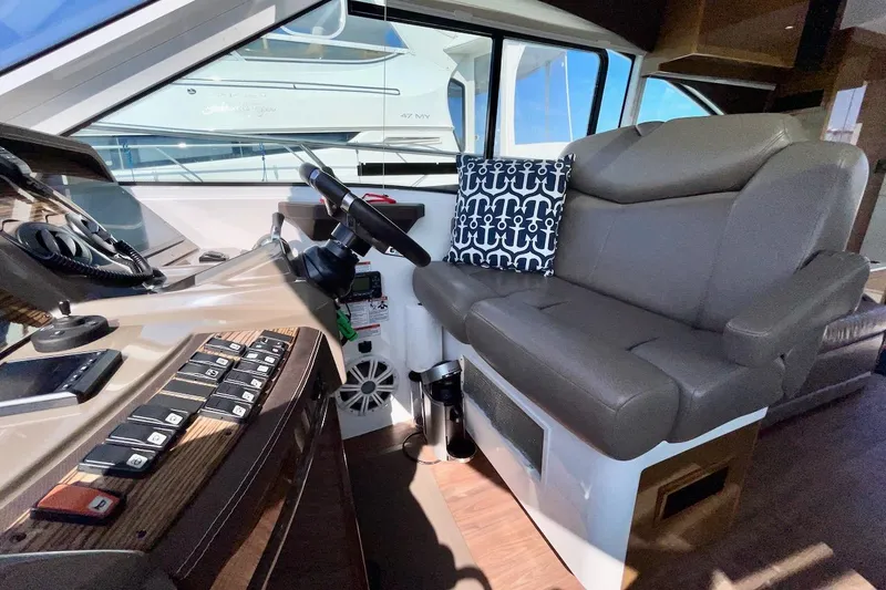 Slide: The Image of 2018 Cruisers Yachts 45 Cantius helm with leather seating and nautical-themed pillow. - 34