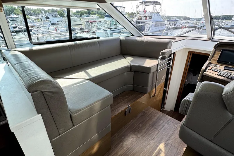 Slide: The Image of Interior of 2018 Cruisers Yachts 45 Cantius with plush seating and marina view. - 36