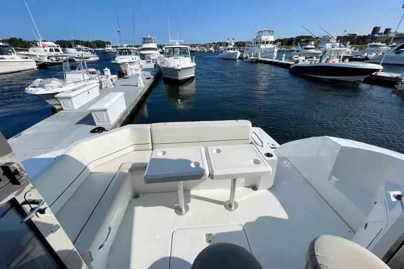 Slide: The Image of 2018 Cruisers Yachts 45 Cantius at marina, featuring spacious seating and docked boats. - 74