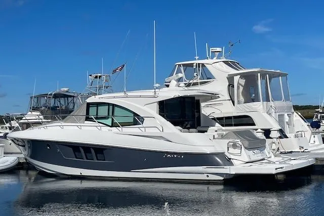 Slide: The Image of 2018 Cruisers Yachts 45 Cantius docked in a marina under clear blue skies. - 78