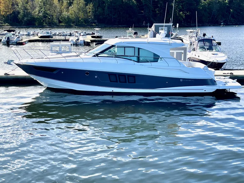 The Image of 2018 Cruisers 45 Cantius yacht docked on a serene lake with surrounding boats. - 0