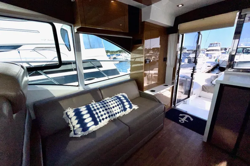 Slide: The Image of Interior of 2018 Cruisers Yachts 45 Cantius with sofa and marina view. - 12