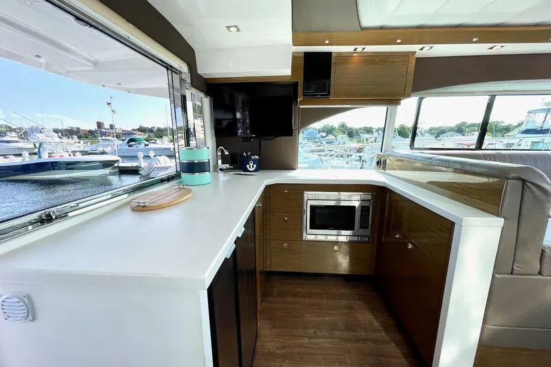 Slide: The Image of Luxurious 2018 Cruisers Yachts 45 Cantius interior kitchen with modern appliances and marina view. - 17