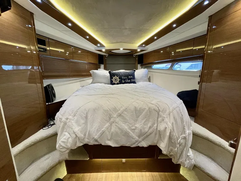 Slide: The Image of Luxurious 2018 Cruisers 45 Cantius yacht bedroom with elegant wood paneling and ambient lighting. - 52