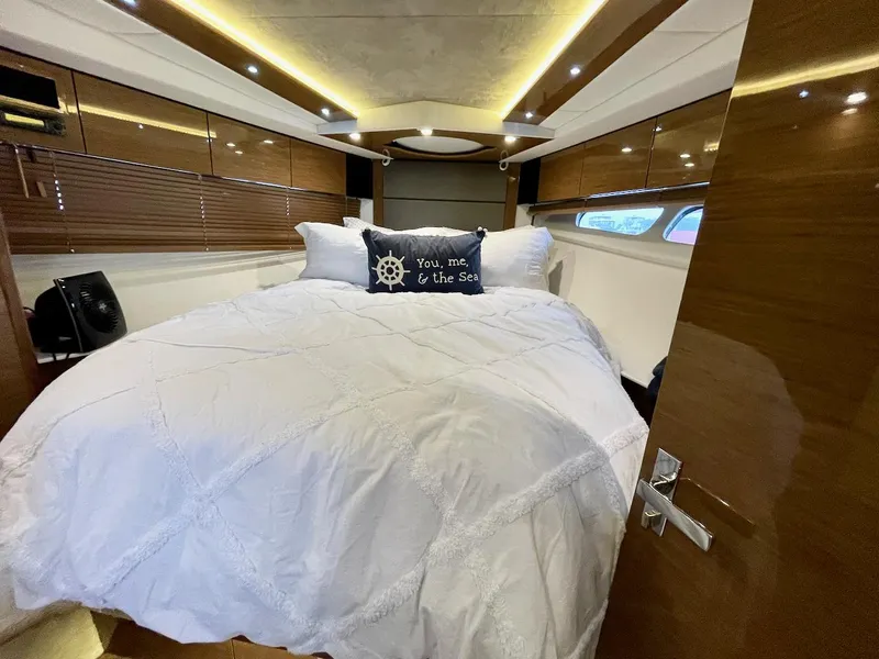 Slide: The Image of Luxurious 2018 Cruisers 45 Cantius yacht bedroom with elegant bedding and ambient lighting. - 54