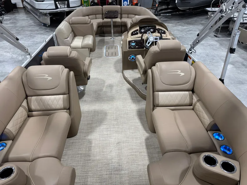 Slide: The Image of 2018 Bennington G 25 pontoon boat interior with luxurious beige seating and modern dashboard. - 6
