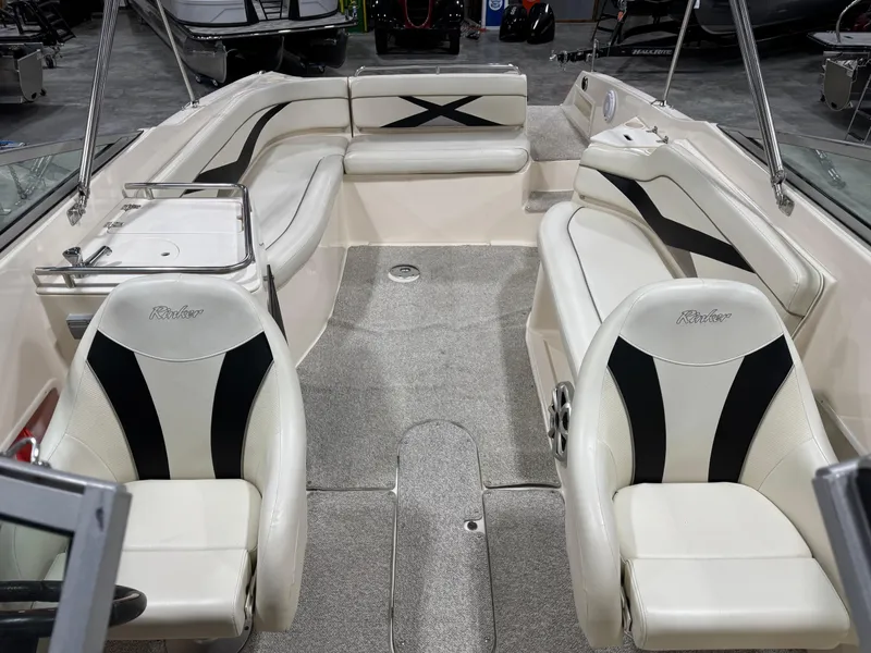 Slide: The Image of 2005 Rinker 282 Captiva Bowrider interior with white and black seating, spacious layout. - 11